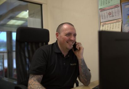 Picture of Terry Lifts installation and maintenance manager on the phone sitting at a desk.