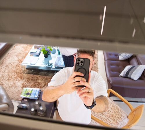 Man on an iphone looking up into a lift shaft.